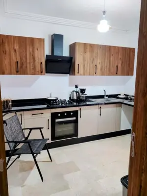 a kitchen with a stove and a chair in it at Luxury Stay Nour Prestige Residence, Gueliz in Marrakech