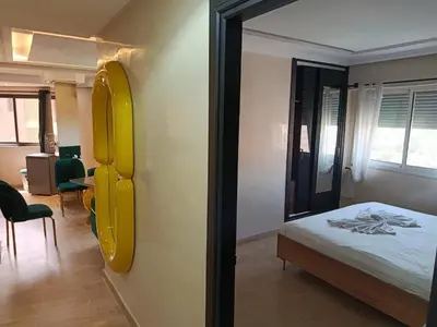 a bedroom with a bed and a yellow mirror at Kamal Atoumi in Marrakech