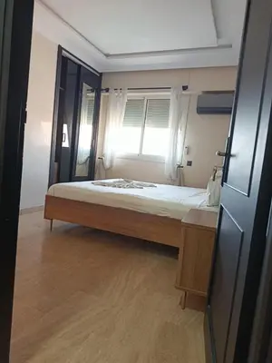 a bedroom with a large bed with a window at Kamal Atoumi in Marrakech
