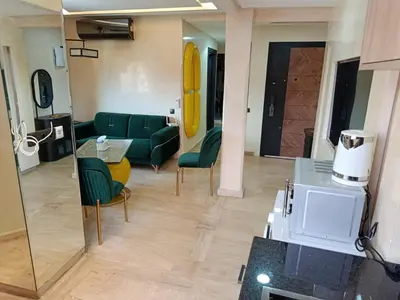 a living room with a green couch and chairs at Kamal Atoumi in Marrakech