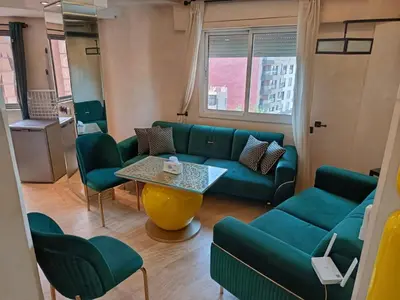 a living room with a green couch and a table at Kamal Atoumi in Marrakech