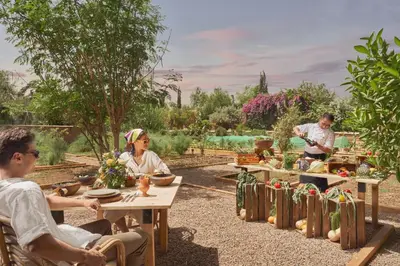 a group of people sitting at tables in a garden at Mandarin Oriental, Marrakech in Marrakech