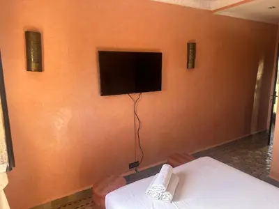 a room with a tv on the corner of a wall at Cosy villa a marrakech in Marrakech