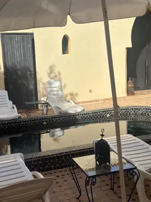 a table with an umbrella and chairs on a patio at Cosy villa a marrakech in Marrakech