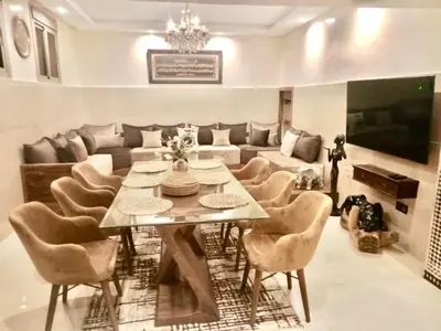 a dining room with a table and chairs and a couch at Oas i Medina & fantastisk terrass in Marrakech