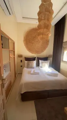 a bedroom with a large bed and a chandelier at Oas i Medina & fantastisk terrass in Marrakech