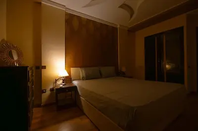 a bedroom with a bed and a table with a lamp at Elegant Apartment with Moroccan Charm in Marrakech
