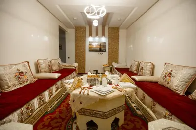 a living room with red couches and a table at Elegant Apartment with Moroccan Charm in Marrakech