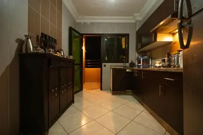 a kitchen with black cabinets and a tile floor at Elegant Apartment with Moroccan Charm in Marrakech