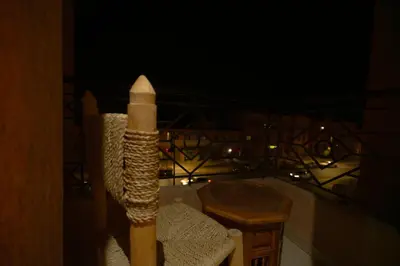 a candle on a chair on a balcony at night at Elegant Apartment with Moroccan Charm in Marrakech