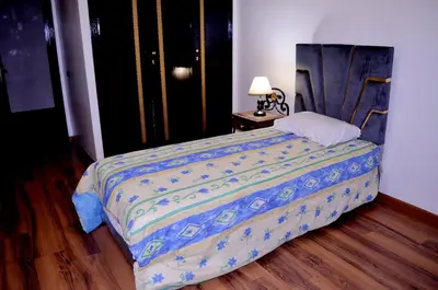 a bedroom with a bed with a blue comforter at Elegant Apartment with Moroccan Charm in Marrakech