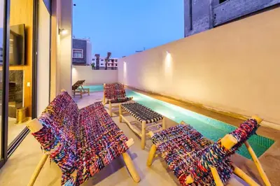 a row of chairs and a swimming pool in a building at Villa moderne à 5 mins du centre-ville de Marrakech in Marrakech