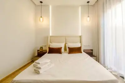 a bedroom with a large white bed with two pillows at Villa moderne à 5 mins du centre-ville de Marrakech in Marrakech