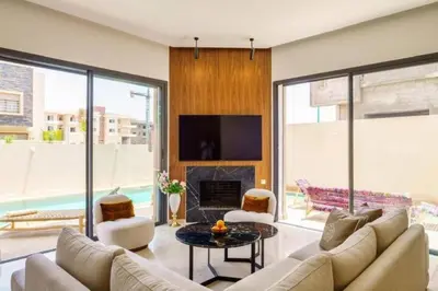 a living room with a couch and a fireplace at Villa moderne à 5 mins du centre-ville de Marrakech in Marrakech