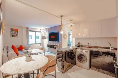 a kitchen and a living room with a table at Modern Flat Gueliz Near Medina Netflix AC in Marrakech