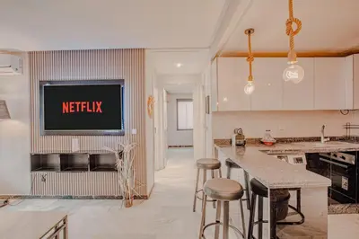 a kitchen with a tv on the wall and a counter at Modern Flat Gueliz Near Medina Netflix AC in Marrakech