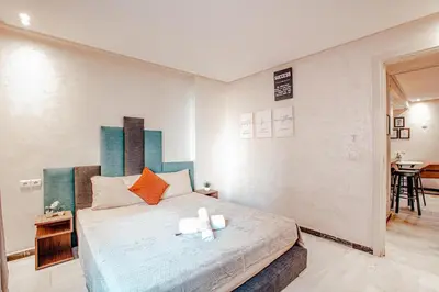 a bedroom with a large bed with two candles on it at Modern Flat Gueliz Near Medina Netflix AC in Marrakech