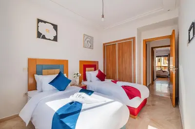 two beds in a room with two beds sidx sidx sidx sidx at 2BR Retreat in Hivernage Center with Pool, Balcony & Parking in Marrakech