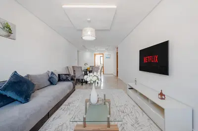 a living room with a couch and a tv at 2BR Retreat in Hivernage Center with Pool, Balcony & Parking in Marrakech
