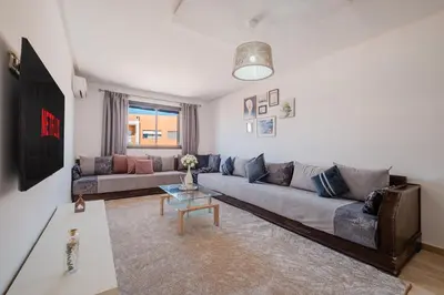 a living room with a couch and a table at 2BR Retreat in Hivernage Center with Pool, Balcony & Parking in Marrakech