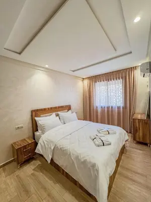 a bedroom with a large bed with white sheets at La perle de Marrakech in Marrakech