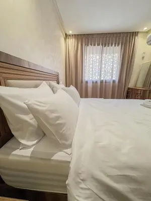 a white bed with white pillows and a window at La perle de Marrakech in Marrakech