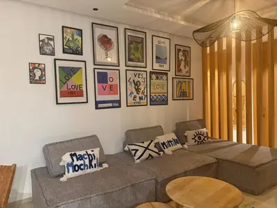 a living room with a couch and pictures on the wall at Villa Marleanis 5 suites 300m2 piscine chauffée privative 11m de long résidence avec gardien in Marrakech