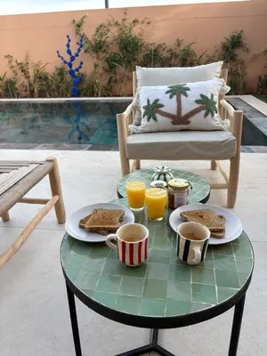 a table with sandwiches and cups of coffee and orange juice at Villa Marleanis 5 suites 300m2 piscine chauffée privative 11m de long résidence avec gardien in Marrakech