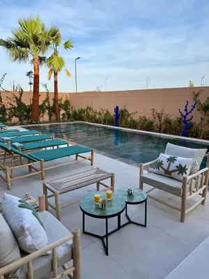 a swimming pool with chairs and tables next to a pool at Villa Marleanis 5 suites 300m2 piscine chauffée privative 11m de long résidence avec gardien in Marrakech