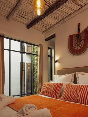a bedroom with two beds and a large window at Maison Etchika in Marrakech