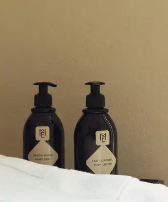 two bottles of lotion sitting next to a wall at Maison Etchika in Marrakech