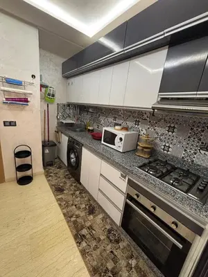 a kitchen with white cabinets and a microwave at Terrasse & Cinéma au cœur de Marrakech in Marrakech