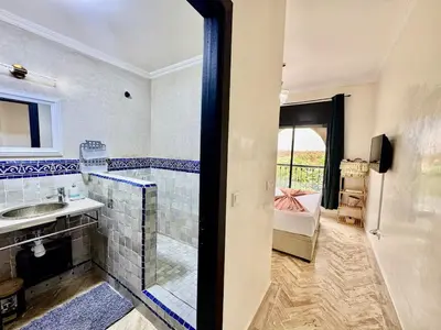 a bathroom with a shower and a sink and a mirror at Stylish Atlas Golf Resort Getaway - Free Breakfast, Rooftop Patio, Pool, Views in Marrakech