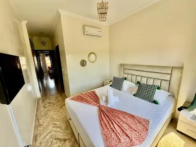 a bedroom with a bed with white sheets and pillows at Stylish Atlas Golf Resort Getaway - Free Breakfast, Rooftop Patio, Pool, Views in Marrakech