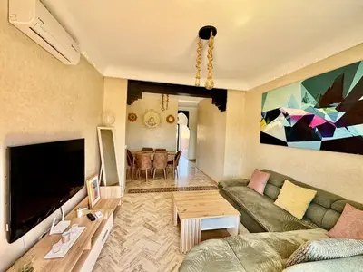 a living room with a couch and a tv at Stylish Atlas Golf Resort Getaway - Free Breakfast, Rooftop Patio, Pool, Views in Marrakech