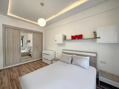 a bedroom with a white bed and a mirror at charming and cozy studio with swimming pool in Marrakech