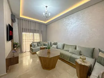 a living room with a couch and a table at charming and cozy studio with swimming pool in Marrakech