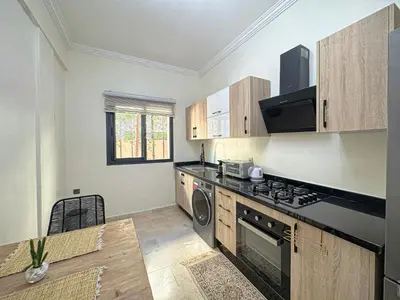 a kitchen with a stove and a dishwasher at charming and cozy studio with swimming pool in Marrakech