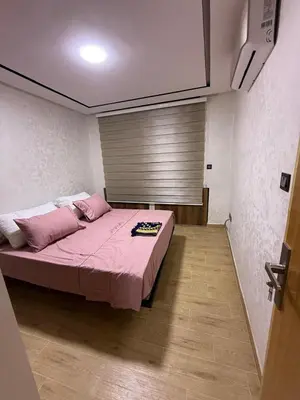 a bedroom with a bed with pink sheets and a window at Nova Gueliz Residence in Marrakech