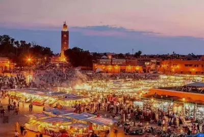 a crowd of people standing around a market at night at Nova Gueliz Residence in Marrakech