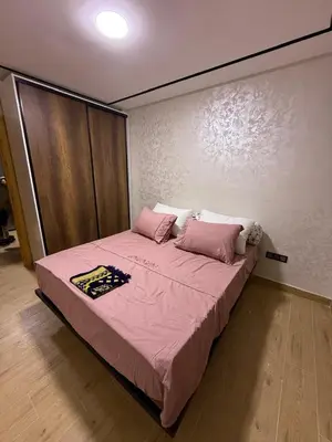 a bedroom with a large bed with pink sheets and pillows at Nova Gueliz Residence in Marrakech