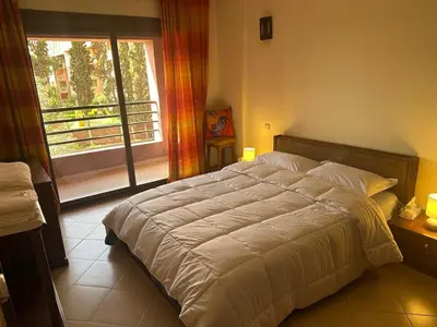 a bedroom with a large bed and a window at Hivernage Bright & Spacious 2-Bedroom Apartment in Marrakech