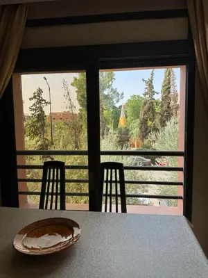 a table with two chairs and a view from a window at Hivernage Bright & Spacious 2-Bedroom Apartment in Marrakech