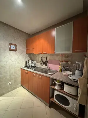 a kitchen with wooden cabinets and a sink at Hivernage Bright & Spacious 2-Bedroom Apartment in Marrakech