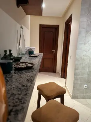 a kitchen with a granite counter top and a stool at Hivernage Bright & Spacious 2-Bedroom Apartment in Marrakech
