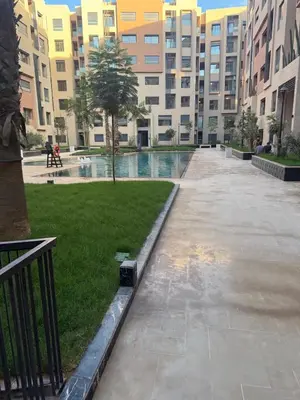 an empty courtyard in a large building with a park at Appartement Guéliz 2 piscines, jacuzzi chauffé et fitness in Marrakech
