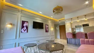 a living room with pink chairs and a table at Luxury Pastel Suite with Balcony & Pool in Marrakech