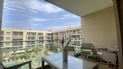a vase with flowers on a table in front of a building at Luxury Pastel Suite with Balcony & Pool in Marrakech