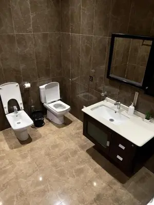 a bathroom with two sinks and a toilet and a mirror at Villa Sara in Marrakech