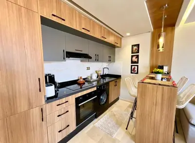 a kitchen with wooden cabinets and a counter top at Modern Gueliz Suite - Balcony Views in Marrakech